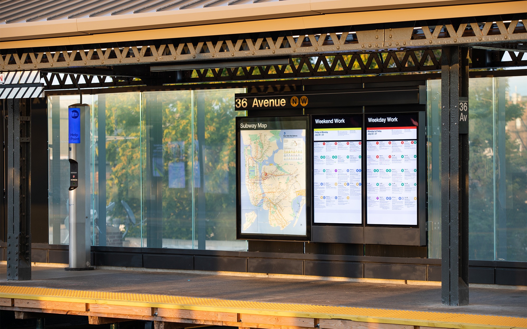 Astoria subway station platform with digital information panels.