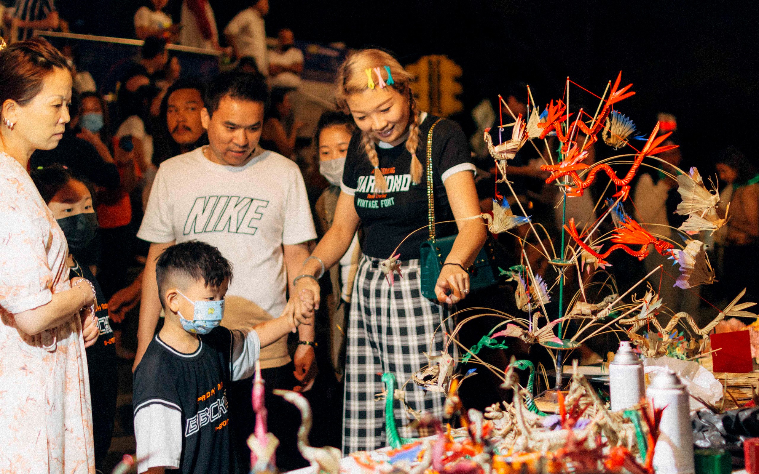 customers looking at an artist’s work at the Chinatown Night Market