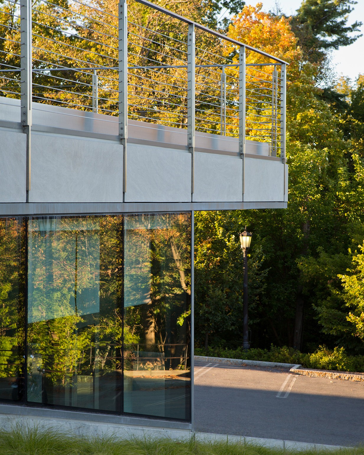 The glass façade reflects the surrounding fall foliage