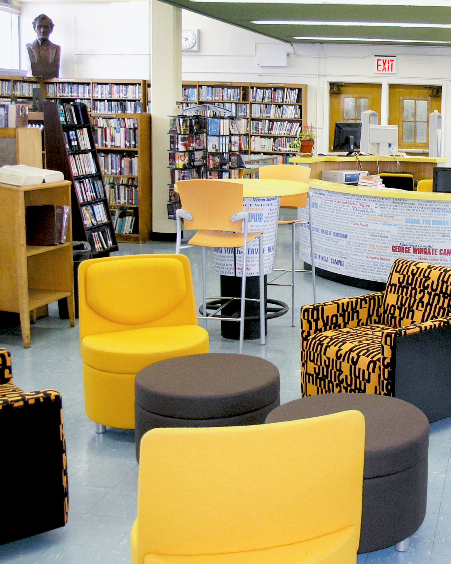 New Visions Public Libraries yellow seating area and help desk