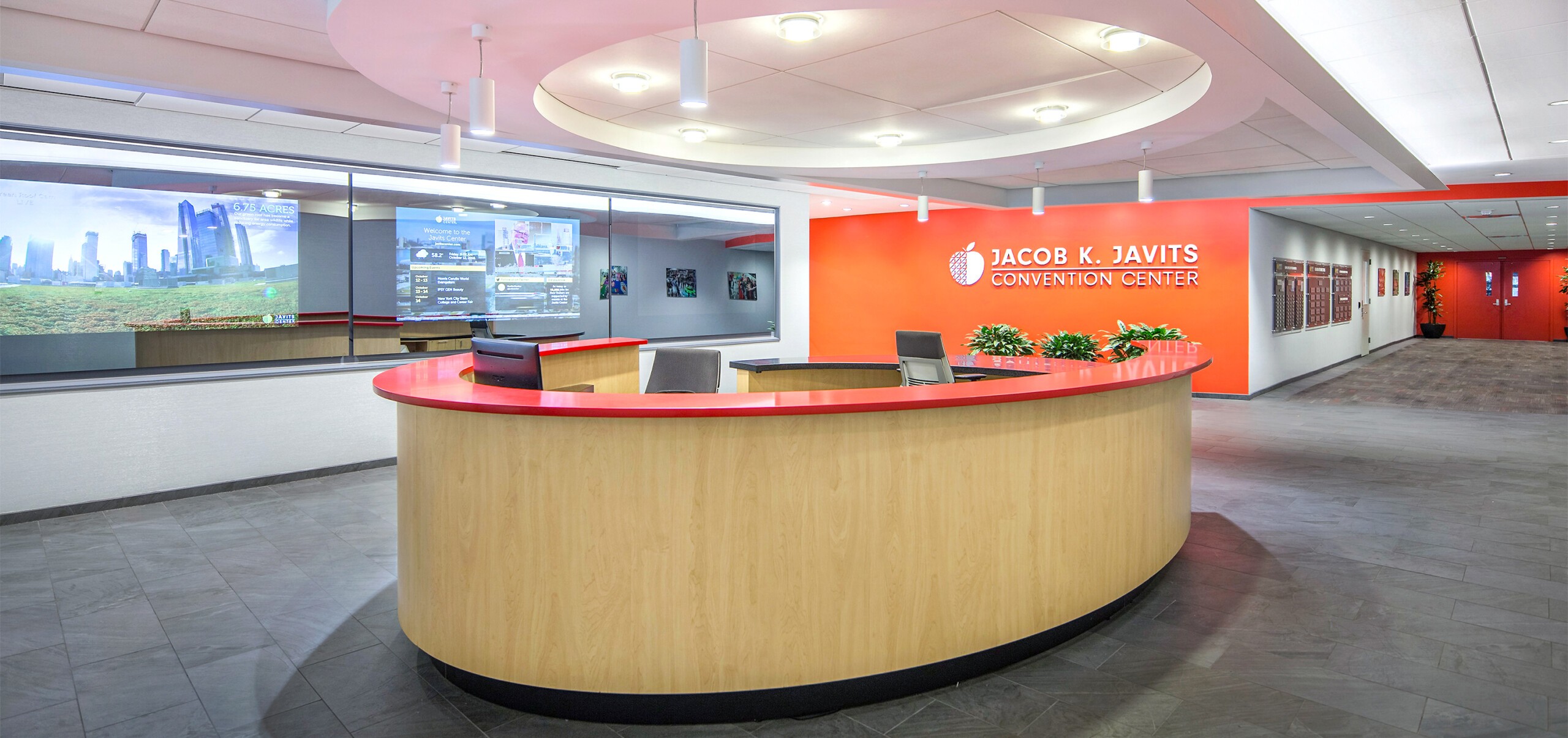 Jacob K. Javits Convention Center custom designed reception desk. In the background, custom designed “dashboard” area of monitors that include live stream from the Javits Green Roof, live news and happenings around the facility.